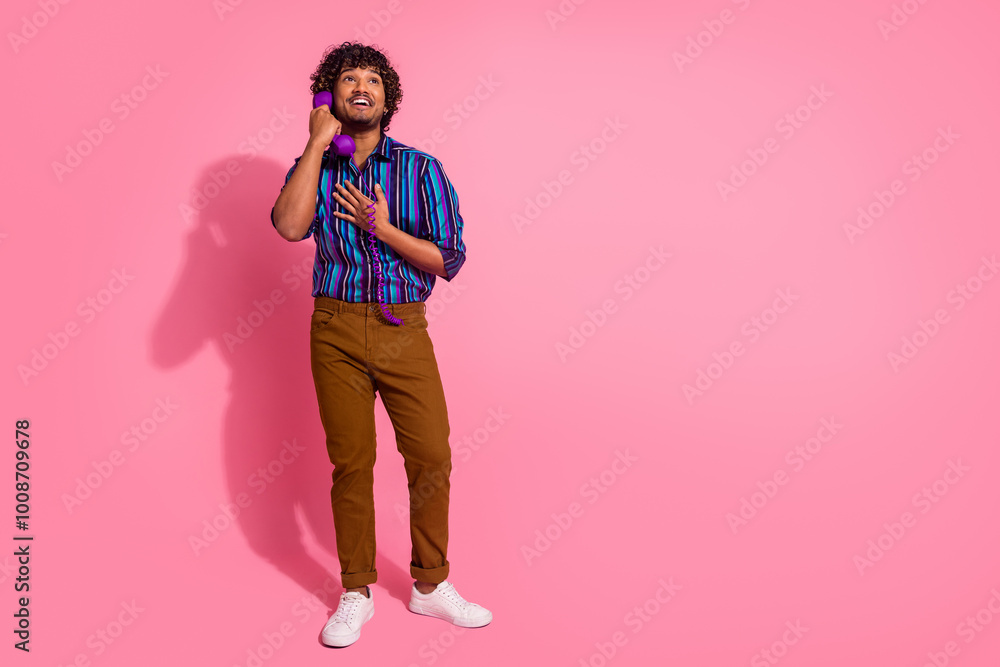 Full body portrait of nice young man speak phone empty space wear shirt isolated on pink color background Full body portrait of nice young man speak phone empty space wear shirt isolated on pink color background