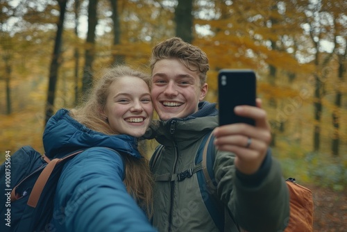 In autumn, an attractive couple takes a selfie in a forest