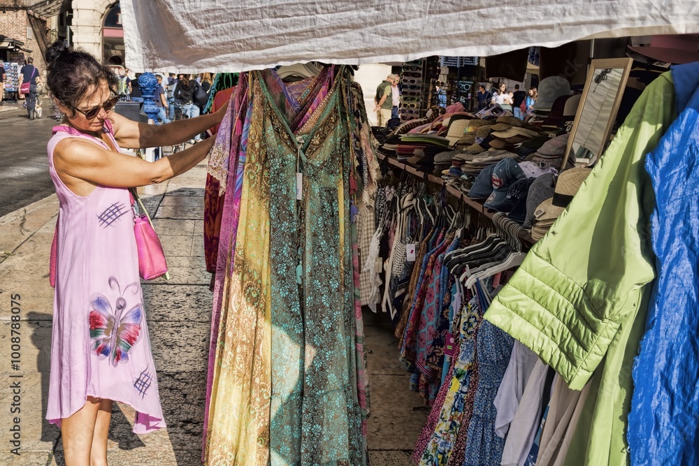verona, italien - 08.10.2023 - eine frau sucht auf der piazza delle erbe ein kleid aus