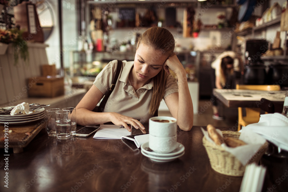 Waitress looking stressed while calculating bill at restaurant table Waitress looking stressed while calculating bill at restaurant table