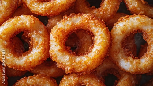 Close-up of fried onion rings, overlapping each other, looking delicious. It is an easy-to-eat food that can be eaten as a snack or between meals.