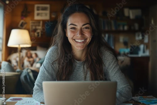 A woman with long brown hair sits in a cozy room, smiling warmly as she works on her laptop, epitomizing the balance of comfort and productivity in home offices.