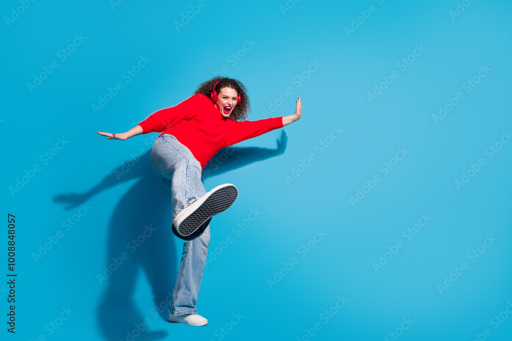 Obraz premium Full size photo of pretty young girl dancing have fun earphones wear trendy red outfit isolated on blue color background