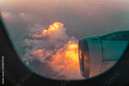 Wallpaper Mural View from an airplane window showcasing clouds illuminated by sunset and the jet engine during a flight over a scenic landscape Torontodigital.ca