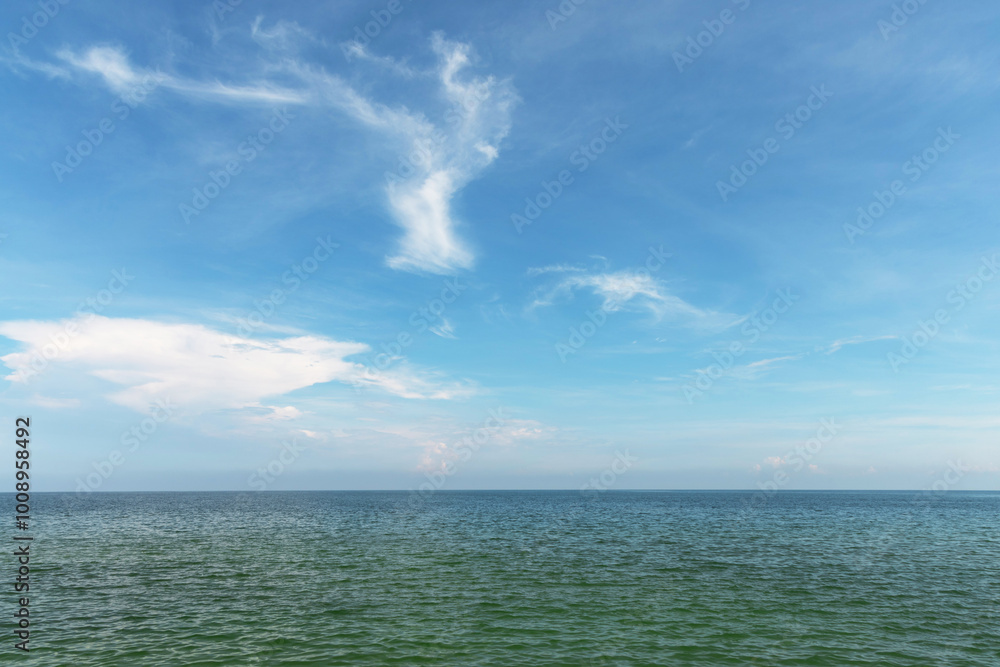 Obraz premium Serene seascape with calm ocean waters meeting a clear blue sky. The horizon line blends smoothly, creating a peaceful and tranquil natural scene. Perfect for backgrounds, travel, and nature.