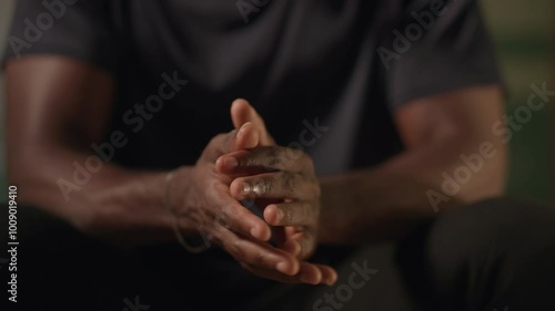 Stress and anxiety, young African man having shaking hands and hand tremors in his bedroom at night.