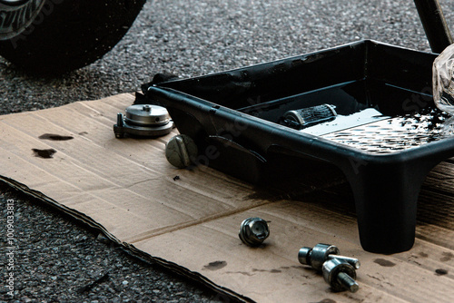 a pallet of used engine oil on a cardboard mat next to the motorcycle photo