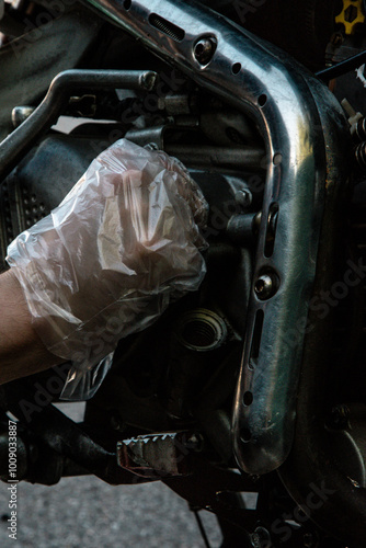 hand replaces the oil filter on the motorcycle and looks at all the details