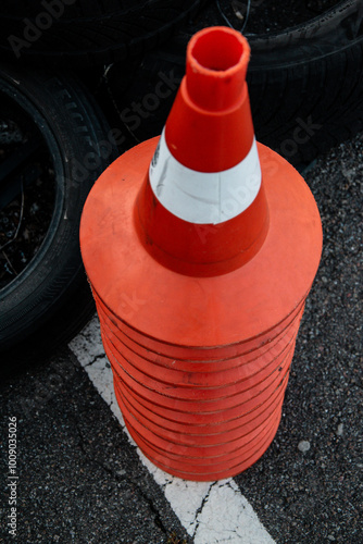 orange traffic cones stacked on asphalt