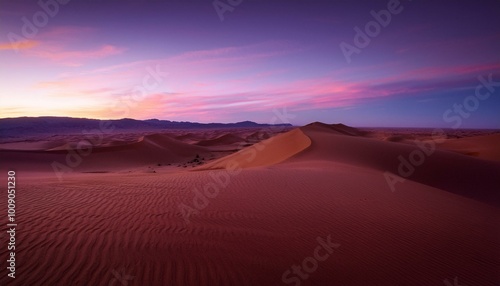 Pink sky over desert dunes