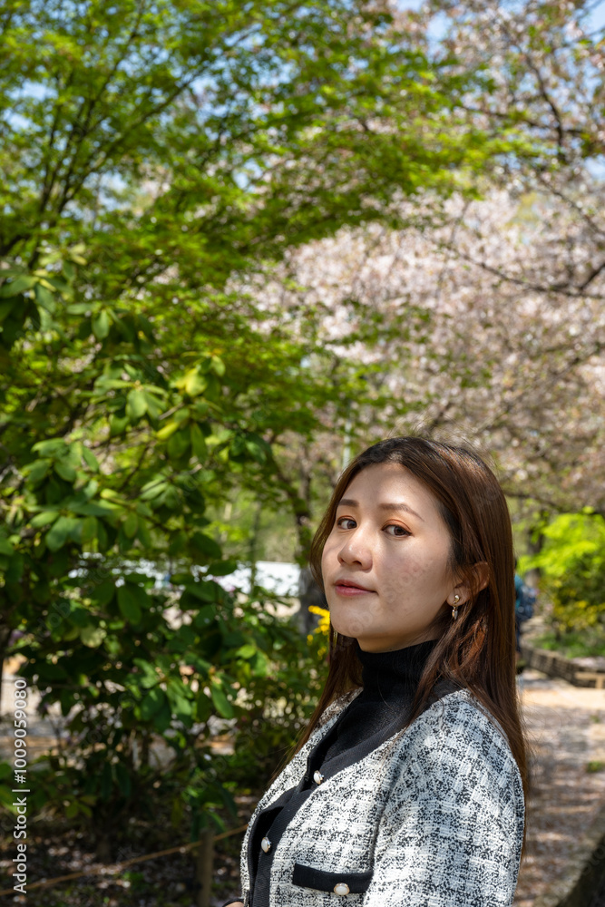 Tokyo, Japan - April 15, 2024: Sakura trees in Ashikaga Flower Park. Asian girl taking photo