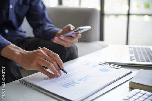 Man calculates the finances by smartphone at home, He sitting on sofa in living room at home