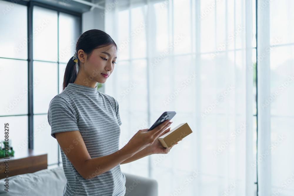 Asian woman sitting on sofa with shopping bags on table her using smartphone shopping online in living room at home Asian woman sitting on sofa with shopping bags on table her using smartphone shopping online in living room at home