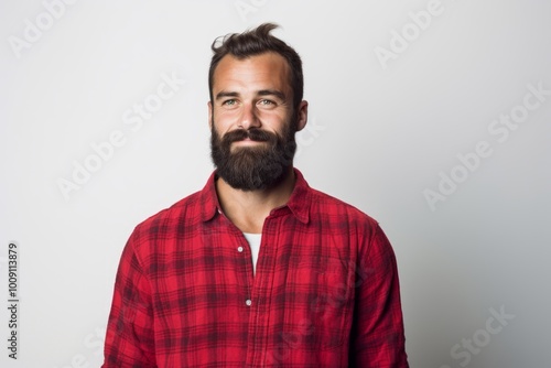 Portrait of a tender man in his 30s dressed in a relaxed flannel shirt isolated on white background