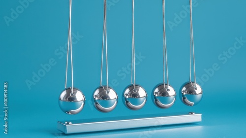 Wide-angle Newton's cradle with glossy metal balls on a blue background.
