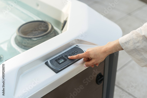 Woman choose comfort temperature and turns on the light in the hot tub photo