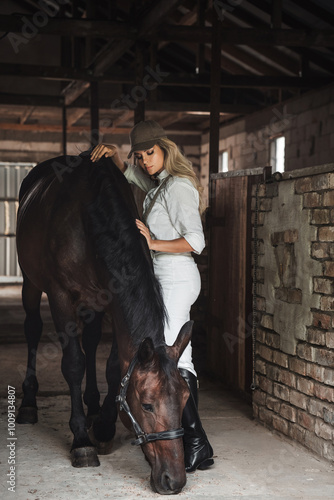 Woman in Equestrian Attire Standing with Horse in Stable