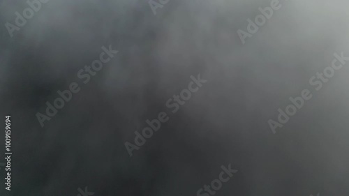 A drone flying through clouds in the sky and fog over a river