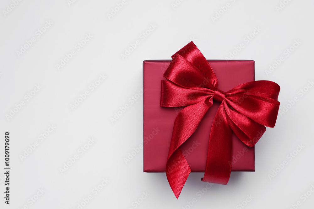 Gift box with bow on light grey background, top view. Space for text Gift box with bow on light grey background, top view. Space for text