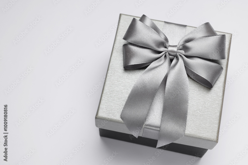 Gift box with bow on light grey background, above view. Space for text Gift box with bow on light grey background, above view. Space for text