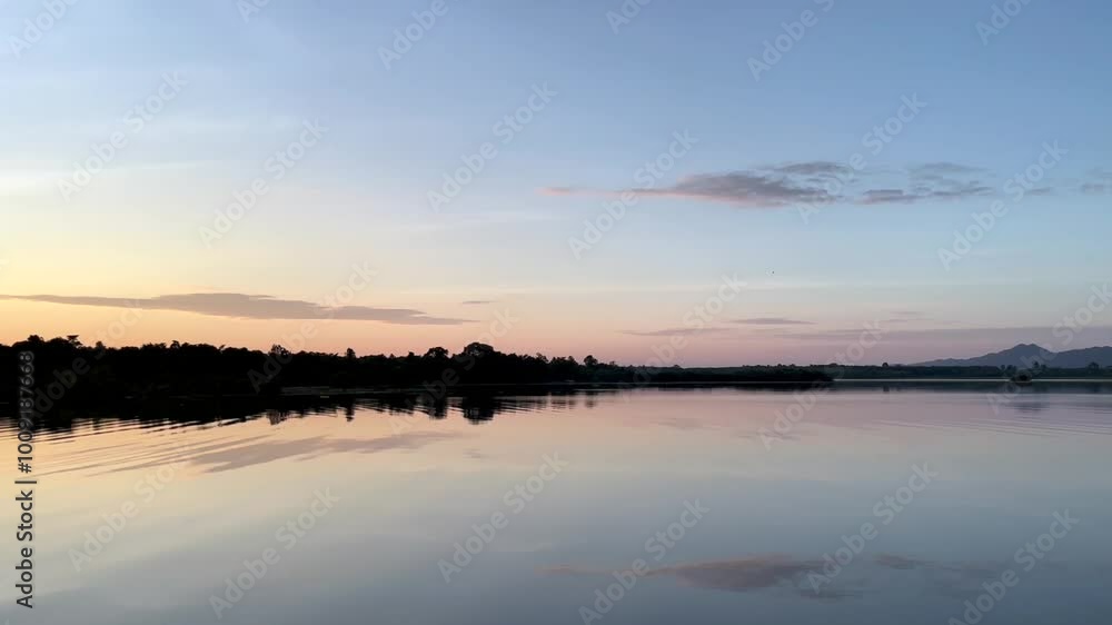 a calm lake at dawn, reflecting the soft hues of the sky on its still surface, silhouette of distant hills and trees frames the horizon, water gently mirroring the serene landscape, sky transitions a calm lake at dawn, reflecting the soft hues of the sky on its still surface, silhouette of distant hills and trees frames the horizon, water gently mirroring the serene landscape, sky transitions