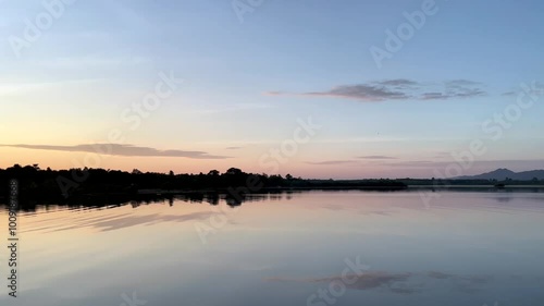 Wallpaper Mural a calm lake at dawn, reflecting the soft hues of the sky on its still surface, silhouette of distant hills and trees frames the horizon, water gently mirroring the serene landscape, sky transitions Torontodigital.ca