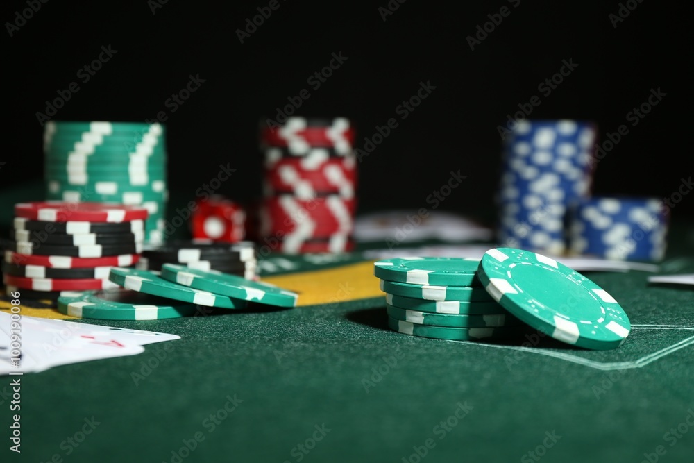 Poker game. Casino chips on green table, closeup Poker game. Casino chips on green table, closeup