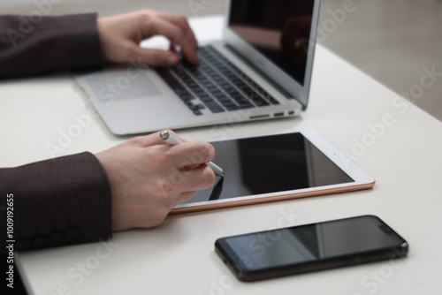 Businessman using different devices at white table indoors, closeup. Modern technology