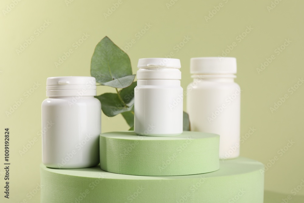 Plastic medical bottles, leaves and podiums on green background, closeup Plastic medical bottles, leaves and podiums on green background, closeup