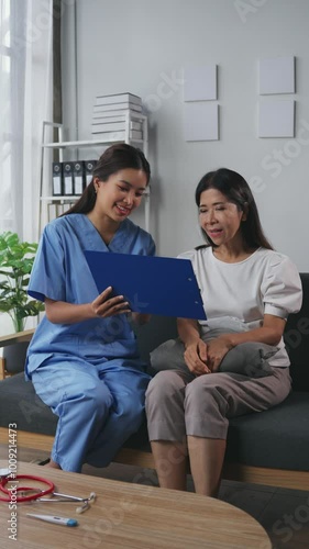 Female doctor showing medical information on a clipboard to a female patient during a consultation in a healthcare setting