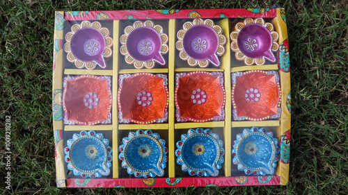 Topview of Decorated Diwali diyas in assorted colour and designs. Handpainted and decorated earthen lamps for Diwali celebration in box package photo