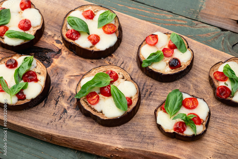 Italian mini pizza . Aubergine (eggplant ) with mozzarella cheese and basil . On rustic background Italian mini pizza . Aubergine (eggplant ) with mozzarella cheese and basil . On rustic background