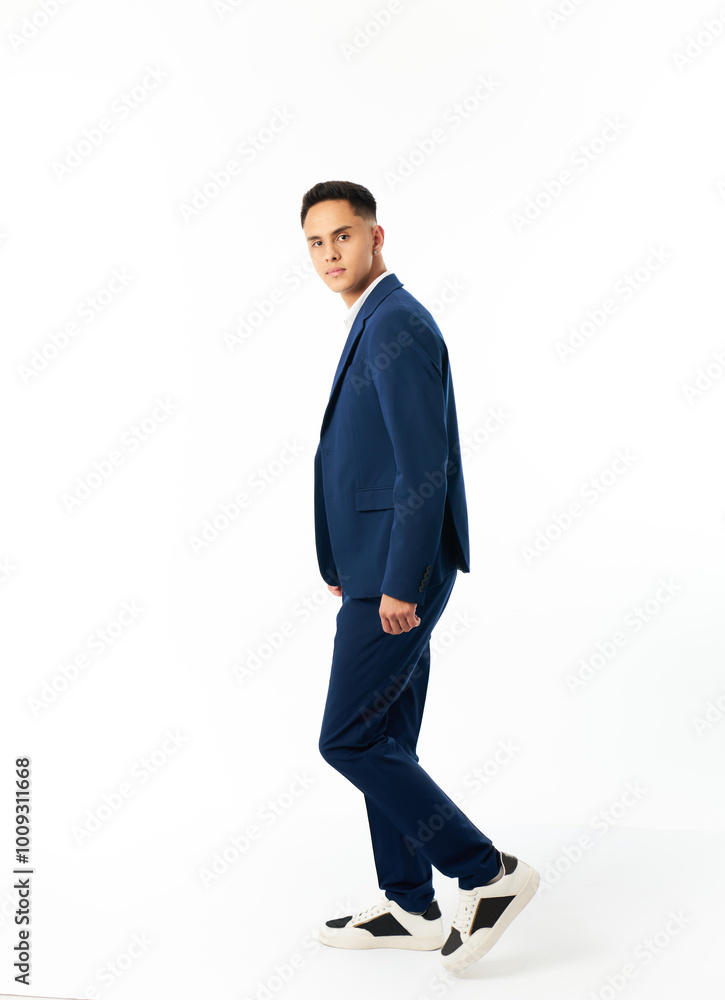 A man in a blue suit and white shirt is standing in front of a white background A man in a blue suit and white shirt is standing in front of a white background
