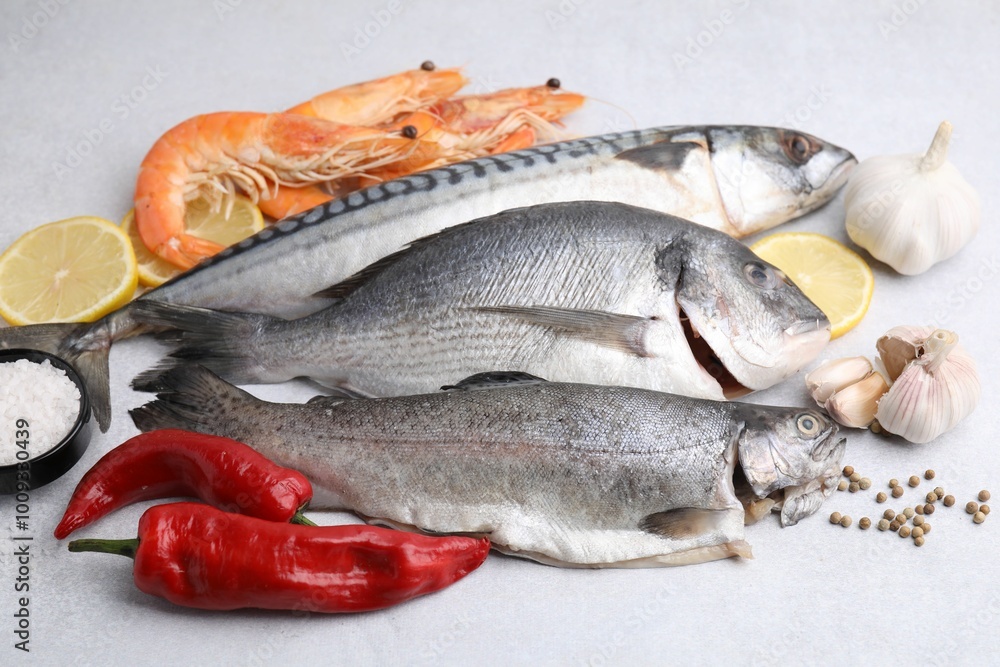 Different fresh sea food with spices on light grey table, closeup Different fresh sea food with spices on light grey table, closeup