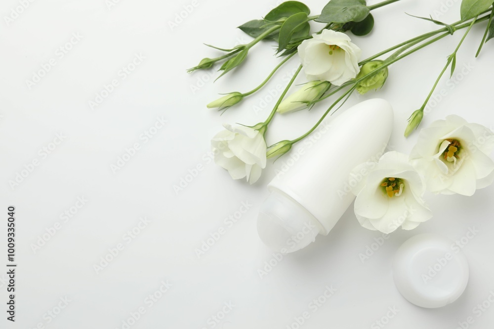 Roll-on deodorant and beautiful eustoma flowers on white background, flat lay. Space for text Roll-on deodorant and beautiful eustoma flowers on white background, flat lay. Space for text