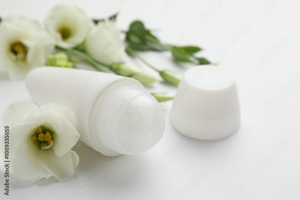 Roll-on deodorant and beautiful eustoma flowers on white background, closeup Roll-on deodorant and beautiful eustoma flowers on white background, closeup