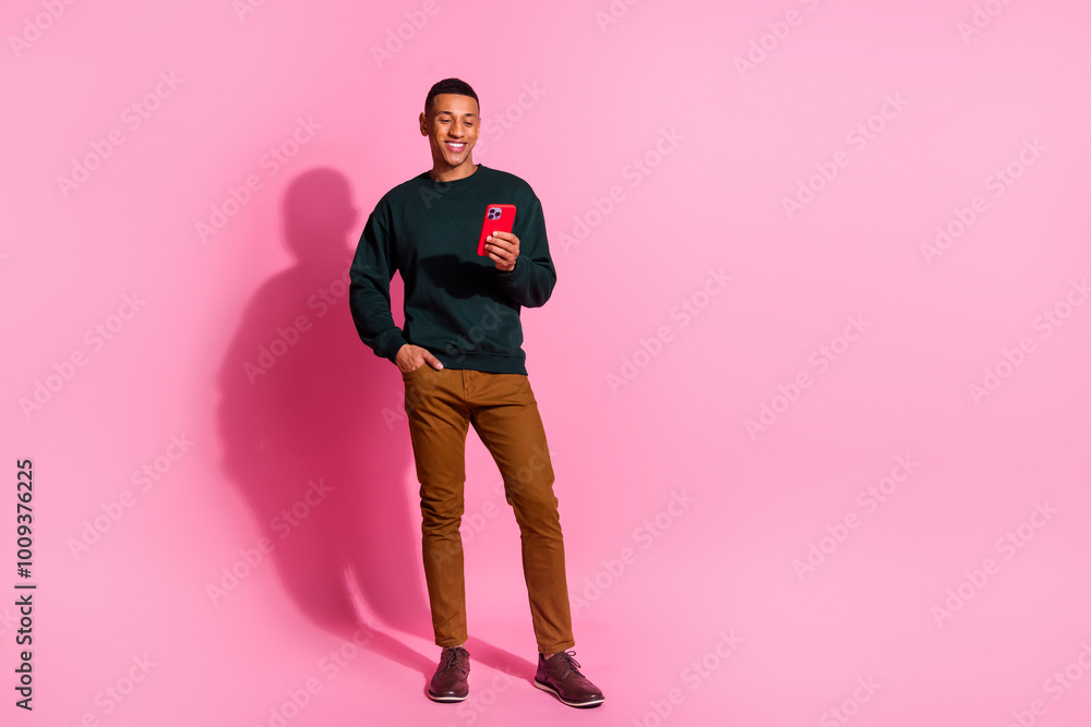 Fototapeta premium Full length photo of funky cool guy dressed pullover chatting modern device emtpy space isolated pink color background