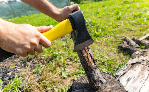 Steel axe, metal ax for wood chopping. Man holding heavy ax. Axe in lumberjack hands chopping or cutting wood trunks.