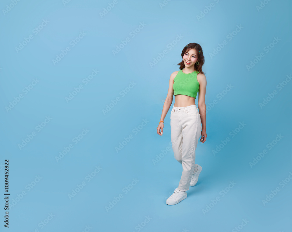 Full length happy asian girl charming person look walking empty space isolated on blue color background. Full length happy asian girl charming person look walking empty space isolated on blue color background.