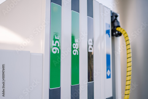 Close-up of fuel pump labels for 95E, 98E, and diesel at a gas station, showing clear fuel type distinctions with green and black labels. photo