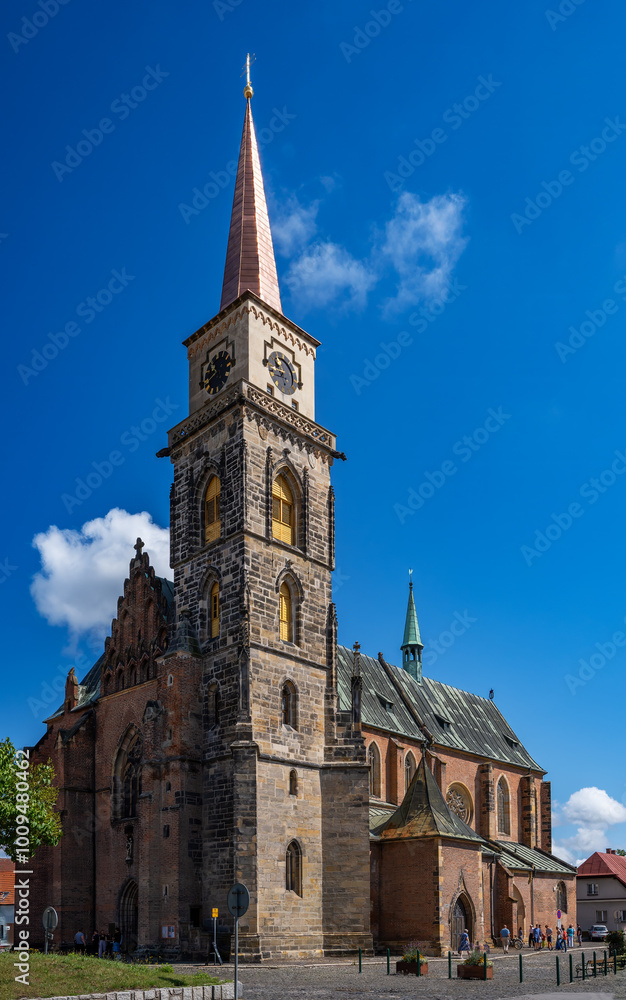 Medieval catholic church of Saint Jilji with gothic High clock tower in sunny autumn day, Nymburk, Central Bohemia, Czech Republic Medieval catholic church of Saint Jilji with gothic High clock tower in sunny autumn day, Nymburk, Central Bohemia, Czech Republic