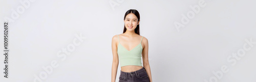 A portrait of an Asian woman wearing a light green tube top against a white wall background.