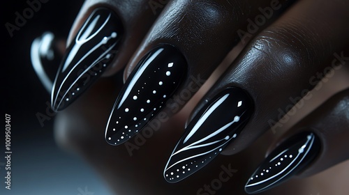 A detailed close-up of matte black nails with white line art, featuring abstract shapes and fine dotted accents. The nails have a velvety finish and are illuminated by soft light,