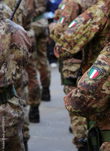 soldiers in the Italian army in camouflage uniform with the flag emblem on the shoulder photo