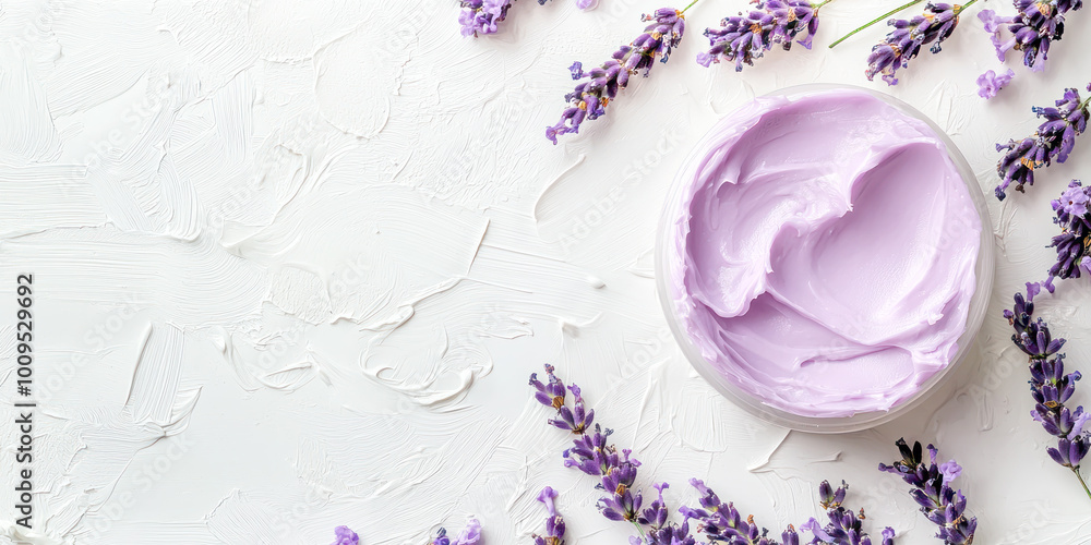 Open jar of lavender cream surrounded by fresh lavender flowers on a white textured background with copy space.
Open jar of lavender cream surrounded by fresh lavender flowers on a white textured background with copy space.