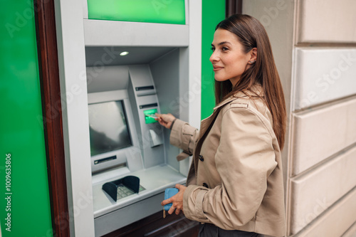 Young woman withdrawing money from atm photo