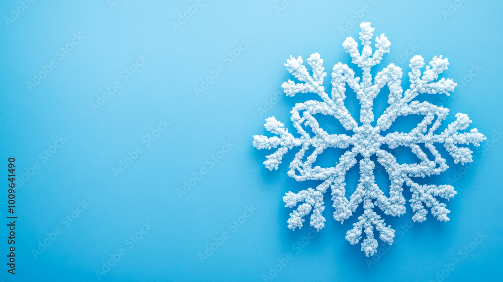 White snowflake ornament lying on blue background White snowflake ornament lying on blue background