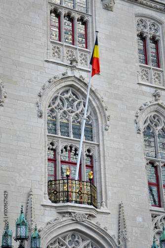 Belgian flag on the flagpole in front of the old facade of the Povinciaal Hof in Bruges
