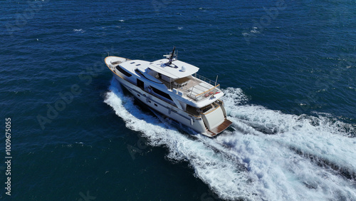 Aerial drone photo of latest technology small yacht cruising near famous beach of Ornos, Mykonos island, Cyclades, Aegean sea, Greece