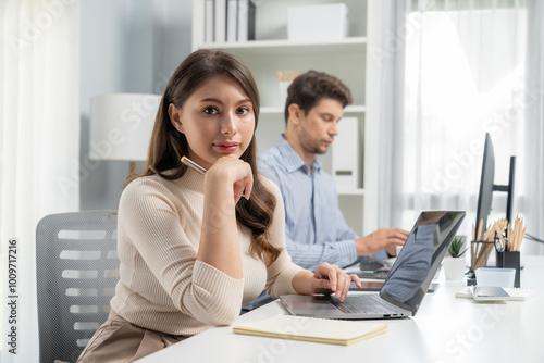 Smiling beautiful woman working on laptop aligning taking note to pose for looking at camera photo shooting portrait profile's business with smart coworker at modern office at morning time. Postulate.